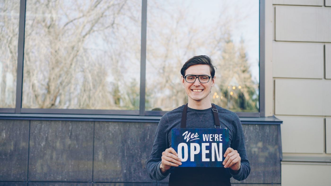 A small business owner outside their shop