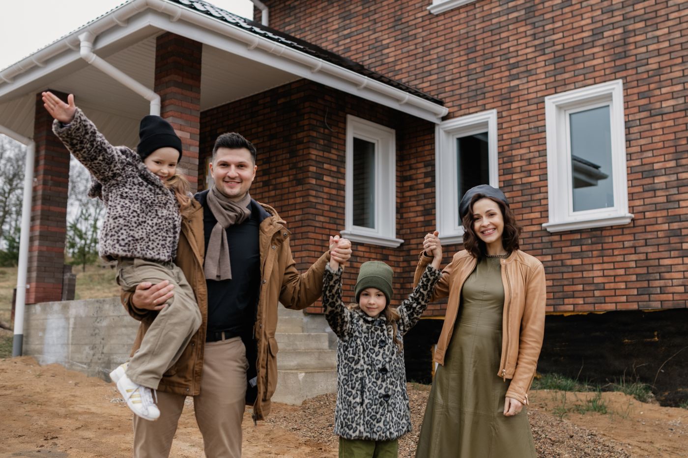 A family celebrating in front of their new home